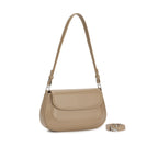 Bolsa baguete minimalista Isabele na cor bege nude. Vista em ângulo destacando o design liso e elegante, a aba frontal curvada, a alça de ombro de tamanho médio e a alça transversal ajustável posicionada ao lado. Preto Caramelo Off White Bege