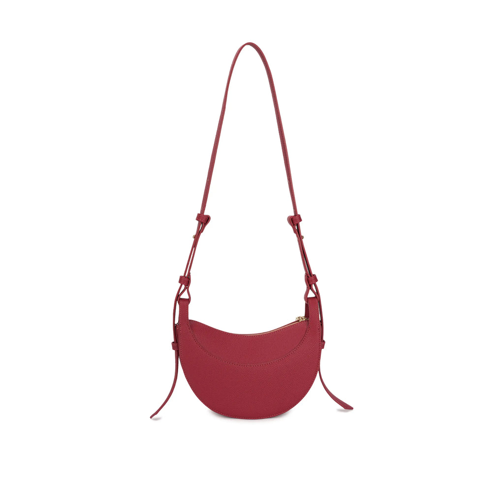 Visão levemente em ângulo da Bolsa Baguete Victoria vermelha, destacando a costura superior contínua e o design liso da peça minimalista. Preto Caramelo Off White Vermelho