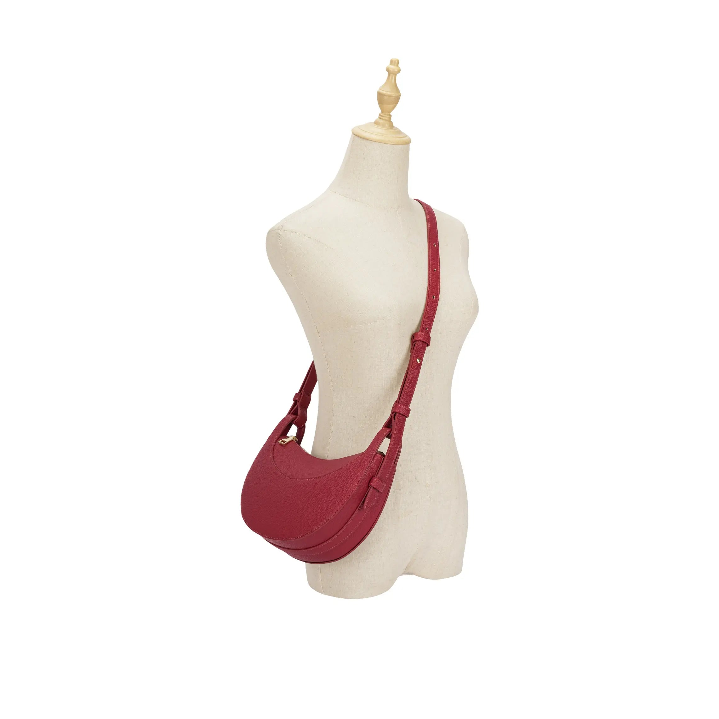 Manequim feminino exibindo a Bolsa Baguete Victoria vermelha a tiracolo, demonstrando o caimento exato da alça longa e a proporção da bolsa no corpo. Preto Caramelo Off White Vermelho