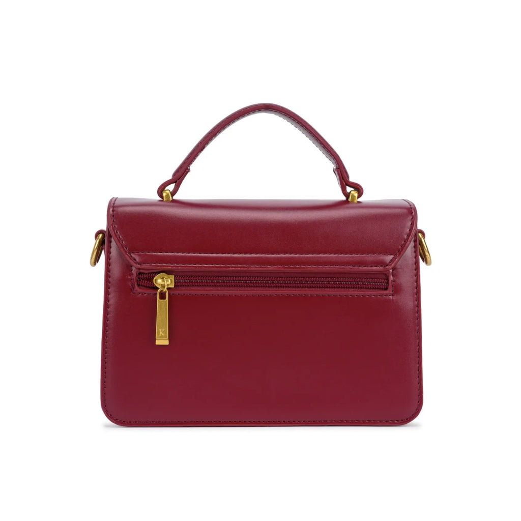 Parte de trás da bolsa de mão Livia vinho, mostrando o design de linhas retas e um bolso externo funcional com fechamento em zíper metálico dourado prático. Preto Caramelo Off White Bordô