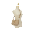 Manequim utilizando a Bolsa Hobo Louise bege na transversal, demonstrando o caimento elegante e a proporção da bolsa em relação ao corpo. Preto Caramelo Off White Bege