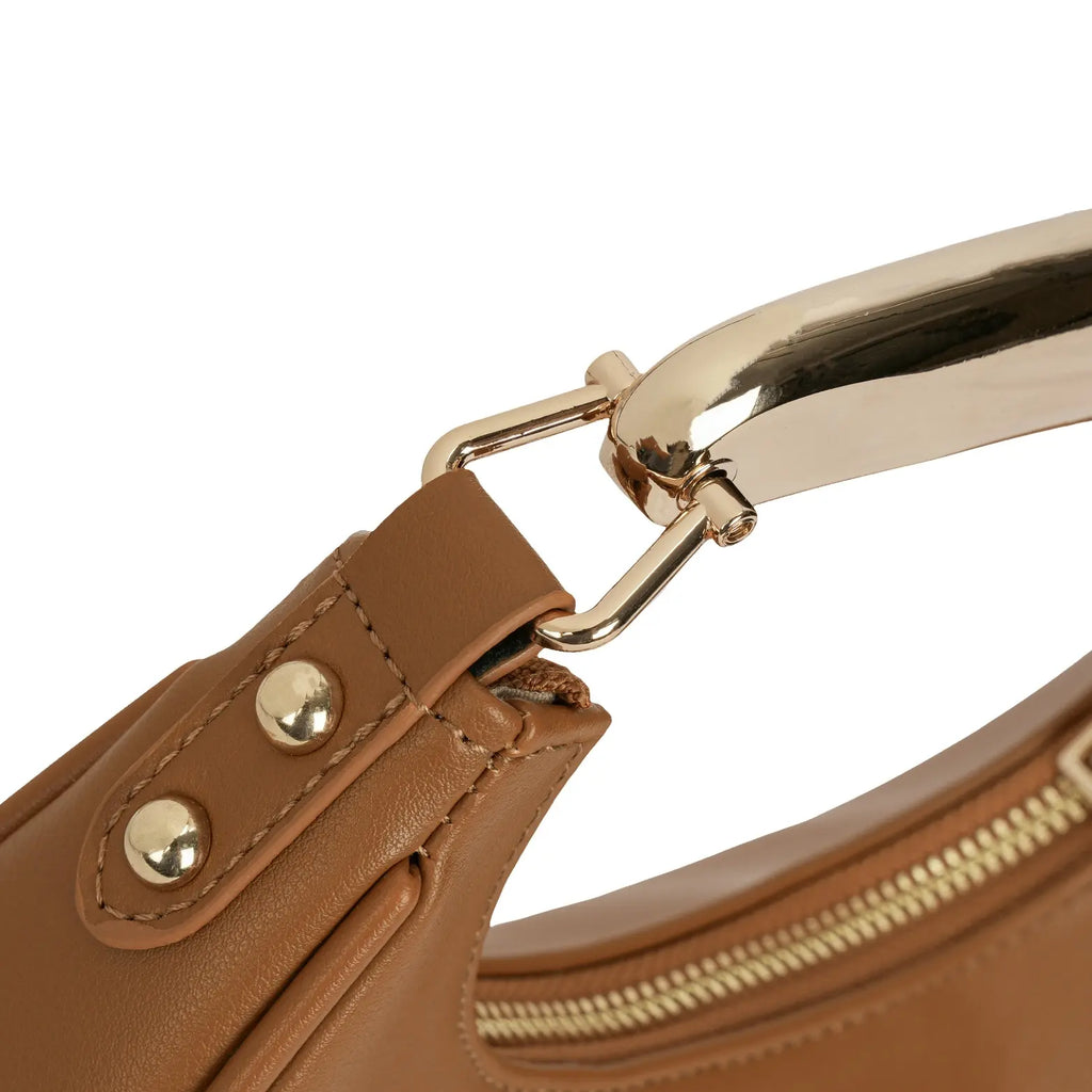 Close-up das ferragens douradas de alta qualidade da bolsa hobo meia lua Marianne caramelo, conectando o corpo da bolsa à alça metálica rígida e à argola da alça longa transversal. Preto Caramelo Off White