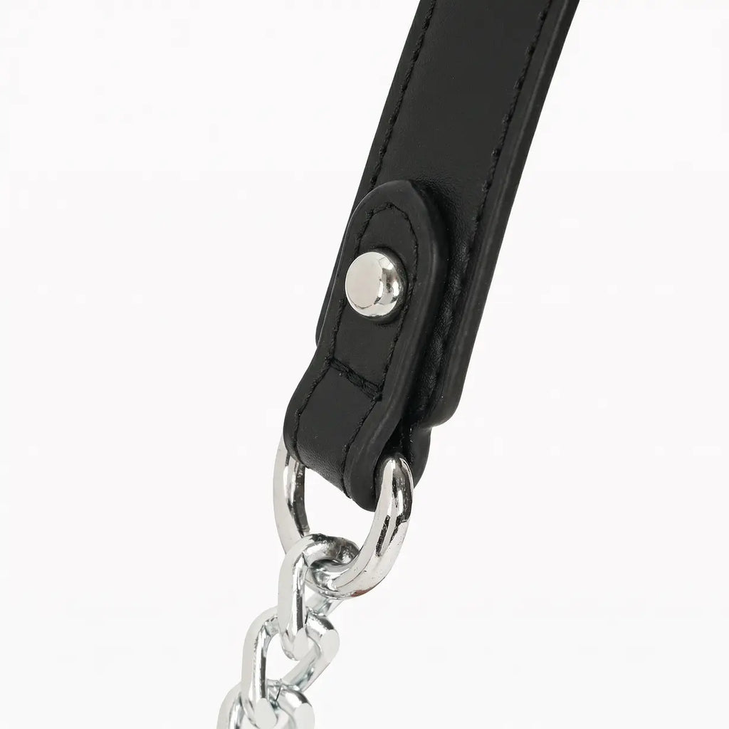 Detalhe aproximado da argola metálica e do rebite prateado que fixam com segurança e muito estilo a parte flexível da alça à base de corrente da bolsa hobo Talessa.