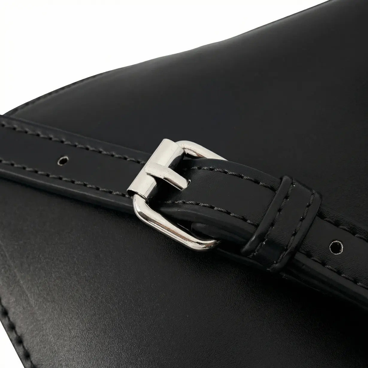 Close-up da fivela metálica prateada de regulagem de tamanho na alça transversal lisa da bolsa hobo Talessa preta, garantindo versatilidade no uso.