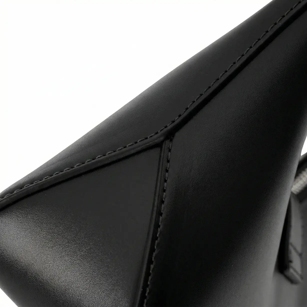 Detalhe em macro da bolsa hobo Talessa preta, evidenciando a textura sofisticada do material e a alta qualidade do acabamento geométrico nas costuras laterais.