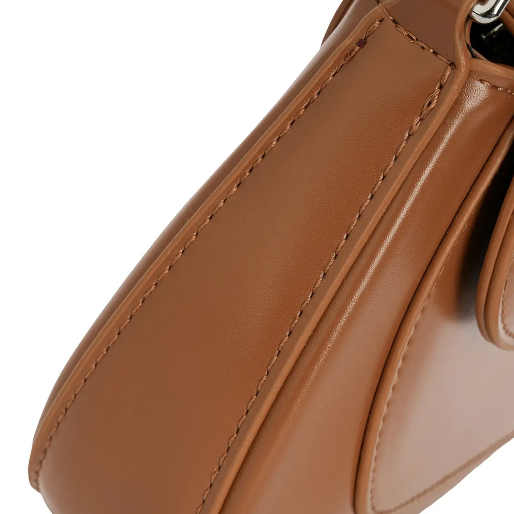 Detalhe em zoom da costura estruturada e do design com recortes arredondados na base firme da Bolsa Baguete Minimalista Isabele marrom. Preto Caramelo Off White Bege