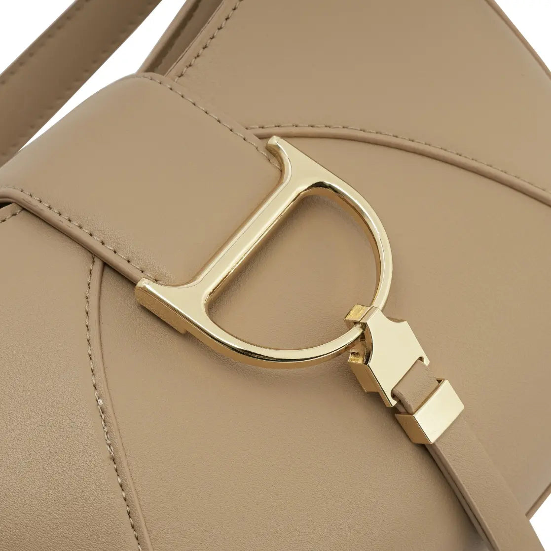 Detalhe em zoom do característico fecho metálico dourado em formato de "D" na frente da Bolsa Hobo Louise bege. Preto Caramelo Off White Bege