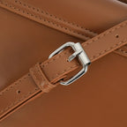 Detalhe macro da fivela prateada com passante para ajuste prático na alça de ombro da Bolsa Baguete Minimalista Isabele marrom. Preto Caramelo Off White Bege