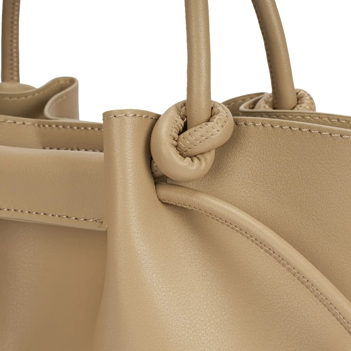 Detalhe aproximado do nó elegante na base da alça de mão e das costuras precisas no acabamento da Bolsa Bucket Beatrice bege. Preto Caramelo Off White Bege