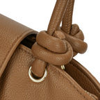 Detalhe macro do nó estruturado em couro na base da alça dupla da bolsa marrom, destacando a argola de metal dourado e o acabamento impecável. Preto Caramelo Off White