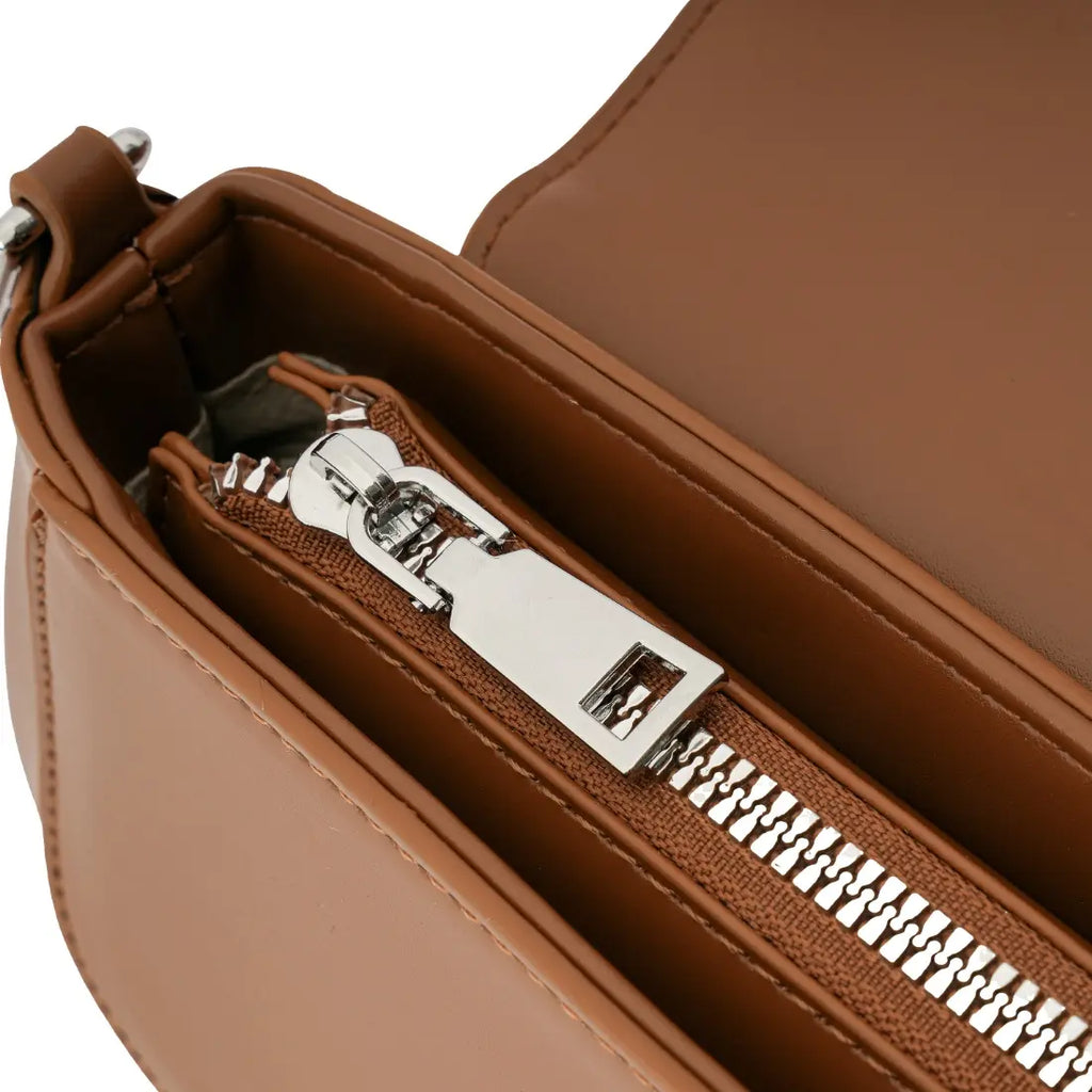 Detalhe em zoom do puxador do zíper interno em metal prateado maciço e do tecido claro e resistente do forro da bolsa marrom. Preto Caramelo Off White Bege