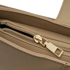 Detalhe macro do puxador do zíper dourado interno e do acabamento impecável do forro da Bolsa Hobo Louise bege. Preto Caramelo Off White Bege