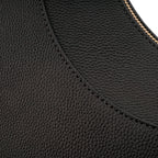 Close-up extremo evidenciando a textura granulada do material e a precisão da costura curva da Bolsa Baguete Victoria preta. Preto [cor:Preto]